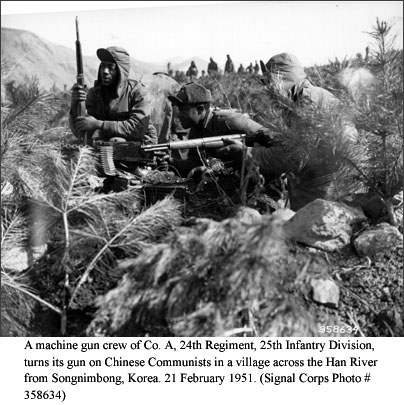 A machine gun crew of Co. A, 24th Regiment, 25th Infantry Division, turns its gun on Chinese Communists in a village across the Han River from Songnimbong, Korea. 21 February 1951. (Signal Corps Photo #358634)