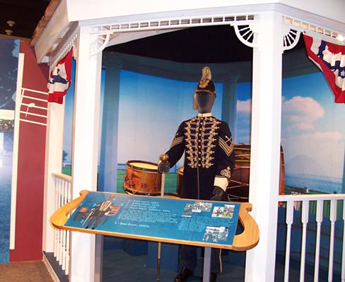Photo: View of a re-created bandstand containing a mannequin depicting a ca. 1900 Drum Major along with a collection of drums.