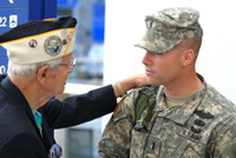 Photo: A veteran and volunteer, greeting a young Soldier home on R&R at DFW.