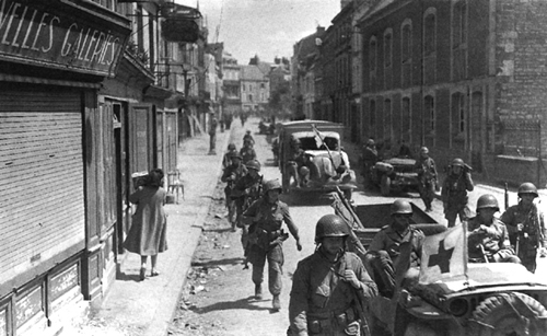 Photo:  Troops, with medical evacuation vehicles, enter Carentan
