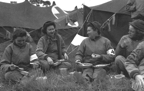 Photo:  Nurses of the 13th Field Hospital, first to land in Normandy to tend the wounded, take time out for a meal