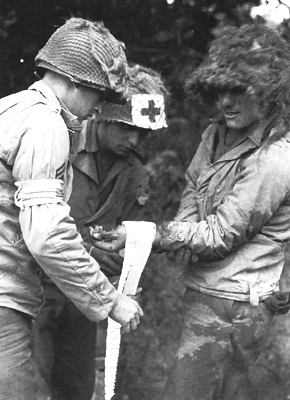 Photo:  Medics with improvised Red Cross insignia on their arms and helmets