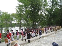 Photo:  Uniformed Reenactors, wearing both “regimental” and “fatigue” uniforms to convey the military composition of the expedition, combine to form a battalion to “march past” in review according to the US Army drill regulations of the Jeffersonian period.