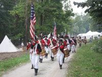 Photo:  Uniformed Reenactors “march past” in review according to the US Army “Manual Exercise” for drill of the Jeffersonian period.