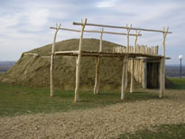 Photo: This photograph shows a newly constructed earth lodge.  The construction of an earth lodge was not an individual responsibility, but rather a community task, in sense that an individual who wanted to build a new lodge could depend on other members of the tribe for assistance.  The platform seen here was used for storage.  It was raised off the ground to keep items out of reach of animals and children.