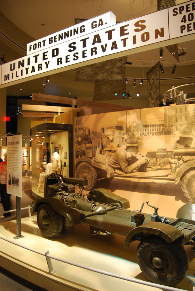 Museum window display of small vehicle with weapon attached.