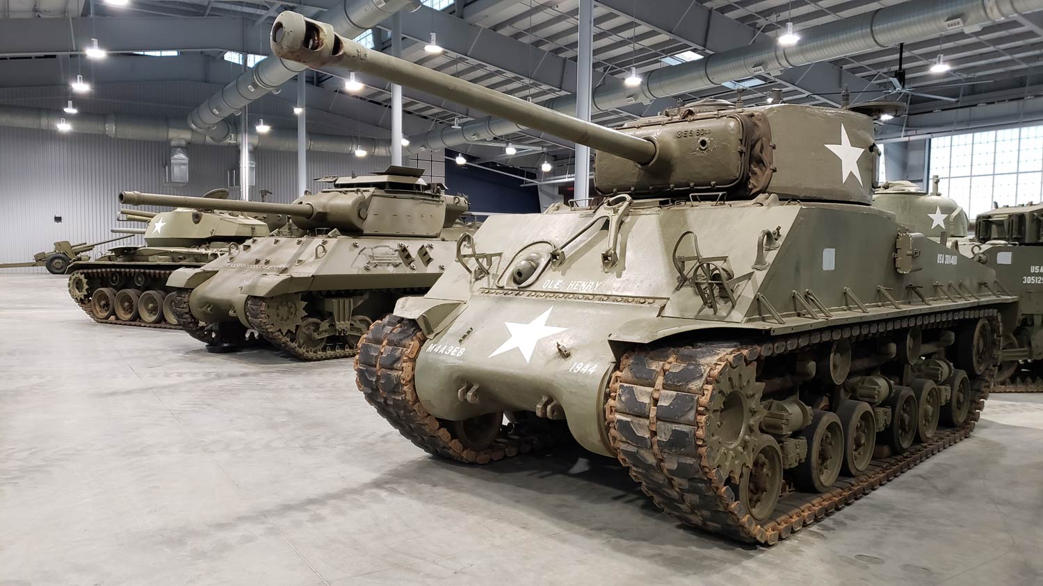 Three US Army AFV's on display in hangar.