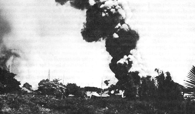 Photo:  Japanese air attack on 10 December 1941 left warehouses on fire at Nichols Field