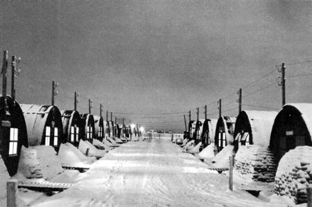 Photo: ARMY POSTS IN ICELAND. Nissen huts on "Main Street" of an Iceland camp.