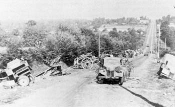 Abandoned German equipment litters a road to Avranches.