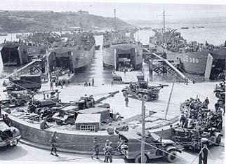 Photograph, Artillery equipment is loaded aboard LSTs at Brixham, England.