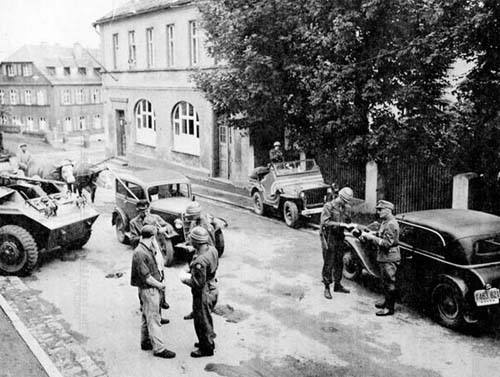 Photo: Road block checkpoint located a short distance from the border were found to be more effective in detecting illegal border crossers than cordon-type patrols along the border. Members of the 28th Constabulary Squadron check the papers of Germans near the point where the Czechoslovak border met the Soviet and US interzonal boundaries. July 1946.