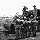 “C” Co 92d Engrs, unloading concertine to establish entanglements all along the LOC, Santo Domingo, DOM REP.  This was on north side of LOC separating from Nationalist area.  This side contained large open areas as can be seen in photo.