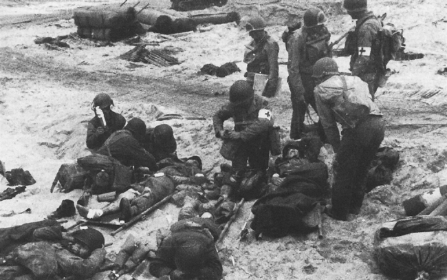 Photo:  Medics administering first aid to invasion casualties on UTAH Beach